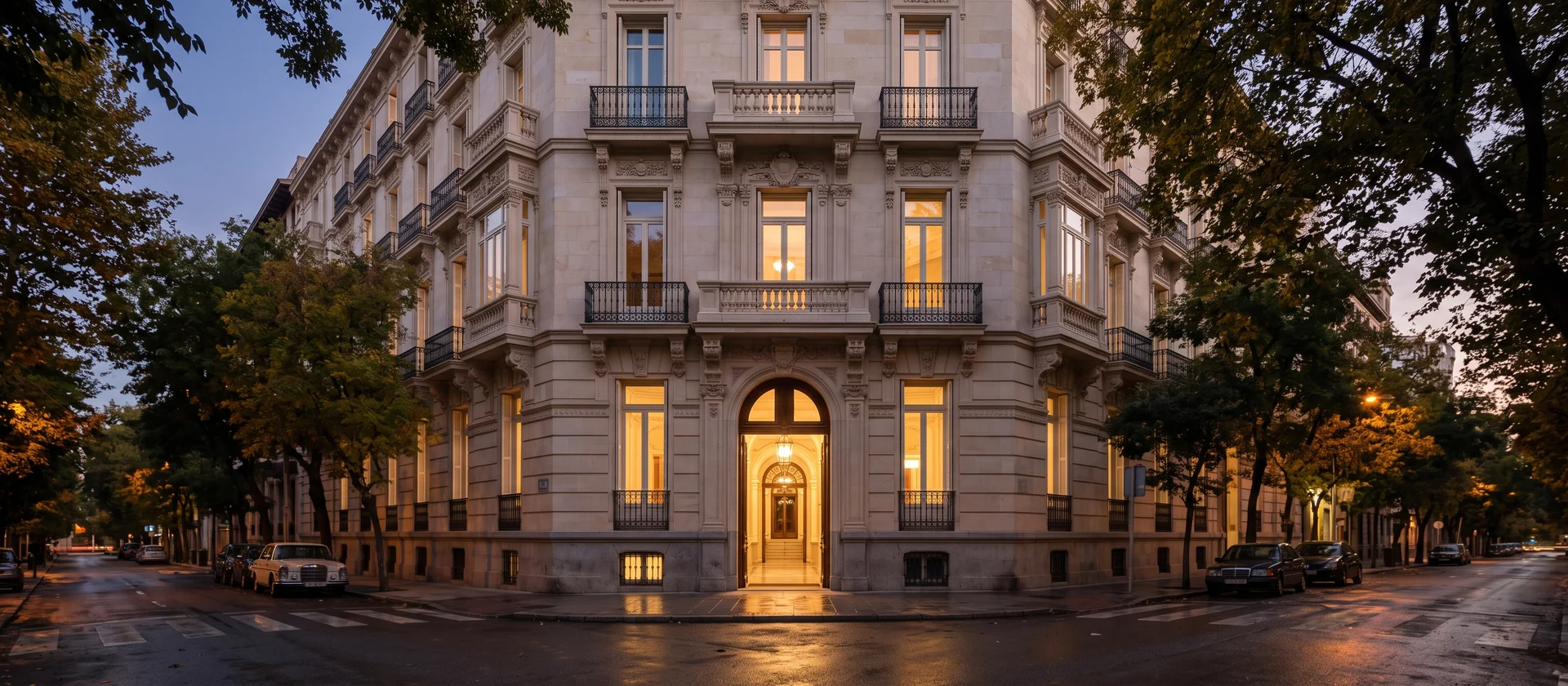 Fachada de un palacio residencial del siglo XIX en el centro de Madrid con balcones de piedra y portal iluminado al atardecer, imagen ilustrativa del proyecto de residencias de marca